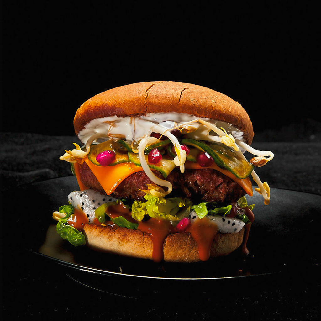 Frisch zubereiteter Asian Dragon Burger Deluxe mit saftigem Patty, knackigem Salat, asiatischen Toppings und würziger Sauce in einem goldbraunen Burger Bun serviert.
